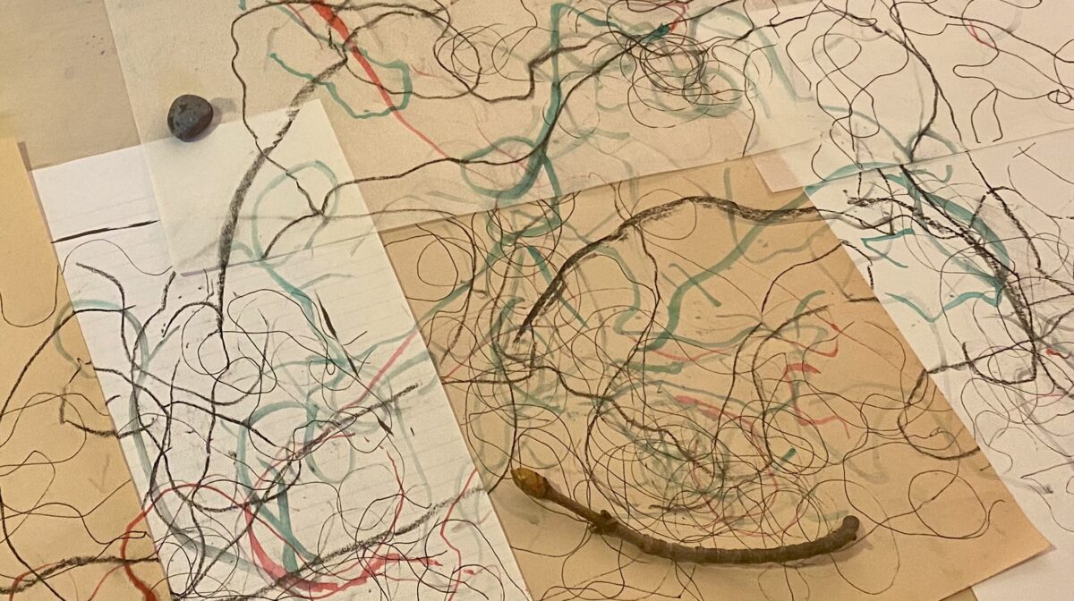 An image showing mark making with a stone and a pen across multiple pages. 